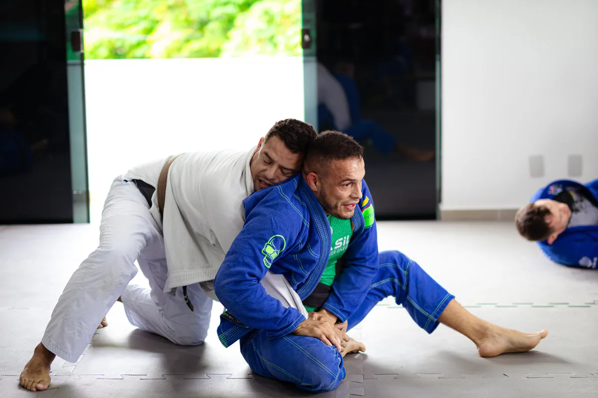 Professor corrigindo postura de aluno durante aula de jiu-jitsu em Sorocaba